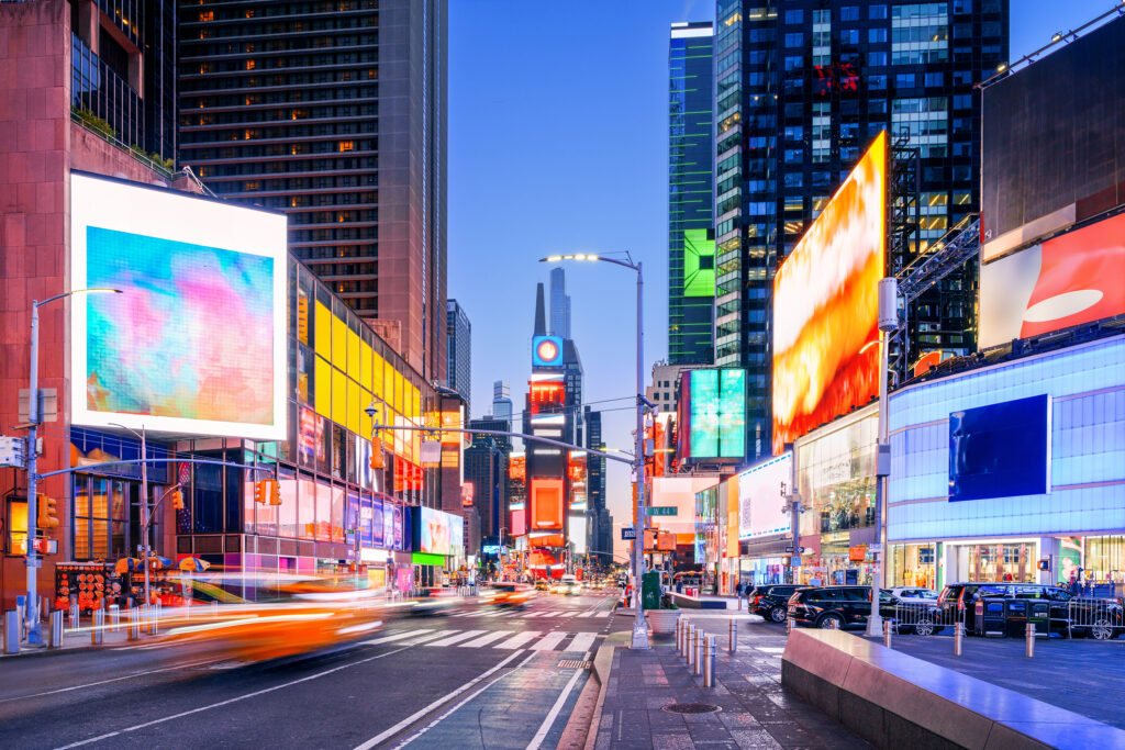 Times Square in Midtown Manhattan at blue hour, where The Promise performed in the 2000s